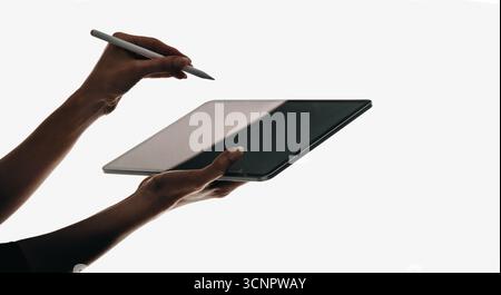 Woman using a stylus on a touchscreen tablet, showcasing modern technology and creative work. The minimalist background emphasizes productivity, creat Stock Photo