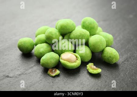 Pile of delicious wasabi coated peanuts on dark textured table, closeup Stock Photo