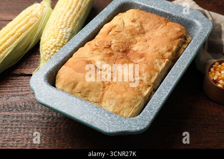 Freshly baked cornbread, seeds and cobs on wooden table, closeup Stock Photo