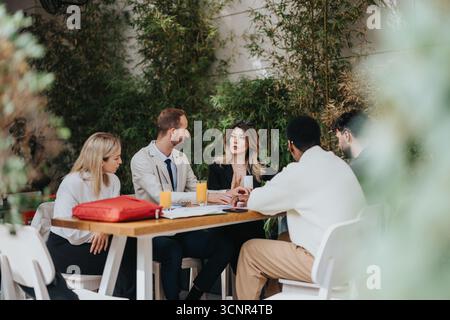Group of professionals having a meeting outdoors at a garden setting Stock Photo