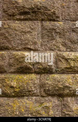 An old stone block wall with a little moss growing on it. Stock Photo