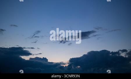 Dramatic storm clouds covering the evening sky with soft fading light, moody natural background for weather, climate and environment concepts. Stock Photo