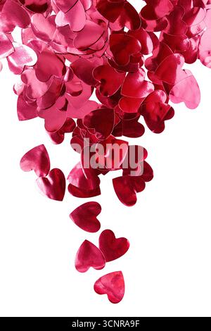 Lots of red metallic heart shaped confetti isolated on white background Stock Photo