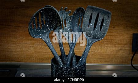 Used black with white dots plastic kitchen utensils Stock Photo