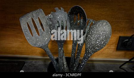 Used black with white dots plastic kitchen utensils Stock Photo