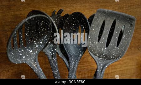 Used black with white dots plastic kitchen utensils Stock Photo