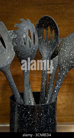 Used black with white dots plastic kitchen utensils Stock Photo