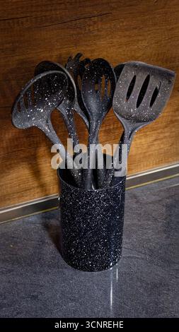 Used black with white dots plastic kitchen utensils Stock Photo