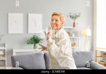 Portrait of mature senior happy joyful woman wearing casual clothes having fun the living room. Stock Photo