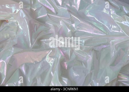 Shiny holographic surface with iridescent folds and colorful waves in retro vaporwave style. Bright abstract texture perfect for modern design and dig Stock Photo