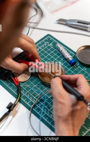Technician repairing electronic device using wires and soldering equipment Stock Photo