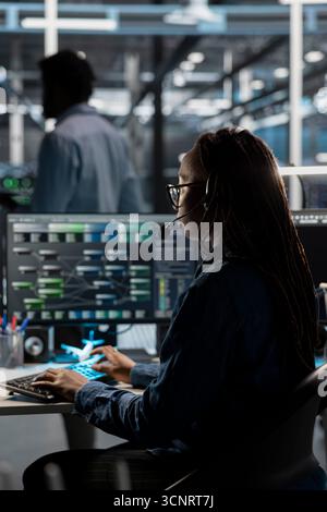 IT specialist in data center looking at node trees, providing technical support to customers. Server room worker carrying out operational technical interventions requested by clients Stock Photo
