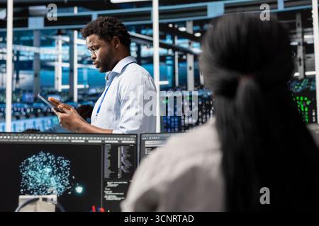 Data center technician deploys AI visualization tool to forecast infrastructure demands and optimize resource allocation. Server farm specialist uses artificial intelligence for predictive maintenance Stock Photo