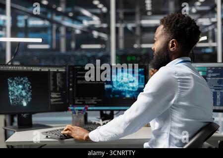 Server room worker using AI powered data visualization to perform demanding computing tasks. Admin in data center uses artificial intelligence predictive analytics for machine learning workloads Stock Photo