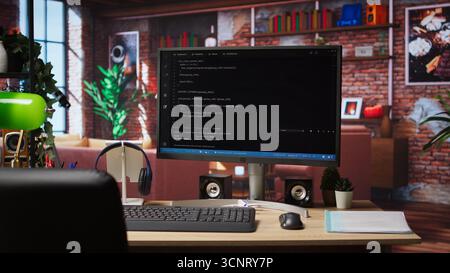 UI on computer monitor in home office with programming script being executed. Empty modern apartment room with coding application used by remote employee to write code, jib up shot Stock Photo
