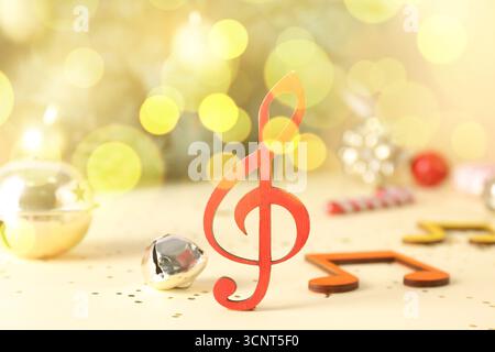 Musical notes, violin clef and Christmas decorations on table, closeup Stock Photo