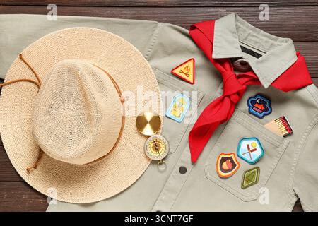Scout uniform with badges and compass on wooden background Stock Photo