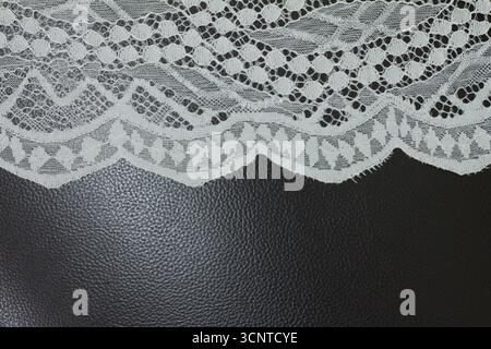 Close-up of white lace on black background. Stock Photo