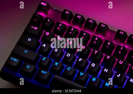 Close-up of a colorful RGB mechanical gaming keyboard illuminated in vibrant hues. Modern computer accessory designed for gaming setups, featuring cus Stock Photo