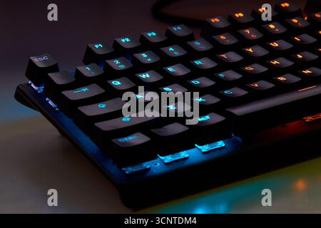 Close-up of a colorful RGB mechanical gaming keyboard illuminated in vibrant hues. Modern computer accessory designed for gaming setups, featuring cus Stock Photo