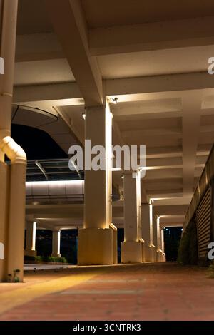 Nighttime view of an illuminated urban underpass with concrete columns and walkway - West Lake in Huizhou, Guangdong Province, China, is a tourist attraction featuring ancient architecture Stock Photo