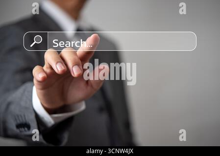 Businessman hand touching a virtual search bar on transparent screen, global internet connection, data access, and online information.technology for f Stock Photo