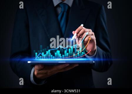 Business analytics with digital graph and growth chart on tablet for data visualization and financial technology with arrow trend and stock market. Stock Photo