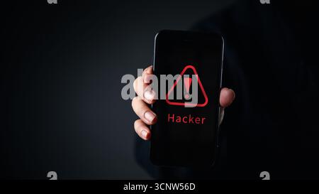 Cybersecurity warning on phone screen with red hacker alert, representing digital mobile threat, online fraud, and data security issues in smartphone Stock Photo
