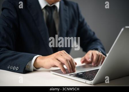 Close-up of hands typing on laptop in a dark workspace. Concept of work focus, remote job, or programming technology digital transformation, and smart Stock Photo