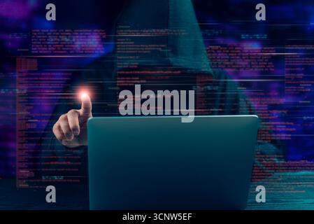 Cybercrime concept.Hacker in hoodie interacts with glowing digital interface, data breach, cyber attack, and the dark side of technology Programmer an Stock Photo