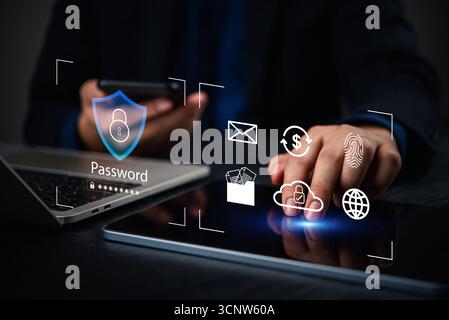 Businessman using smartphone and tablet with digital password and fingerprint icons. Concept of cybersecurity, identity protection, and secure data ac Stock Photo