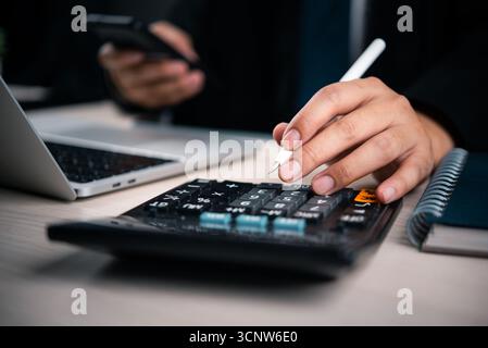 Businessman hand using calculation data analysis finance tax, accounting, planning, budget. Business digital environment Stock Photo