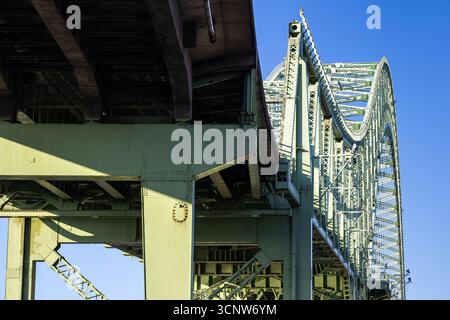 View from beneath the Runcorn Widnes Bridge, also known as the Silver Jubilee Bridge, showing its steel framework and sweeping arch design Stock Photo