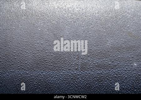 Close up of gray textured surface with water drops and glossy details. Perfect for abstract backgrounds, modern design, and decorative concepts. Stock Photo