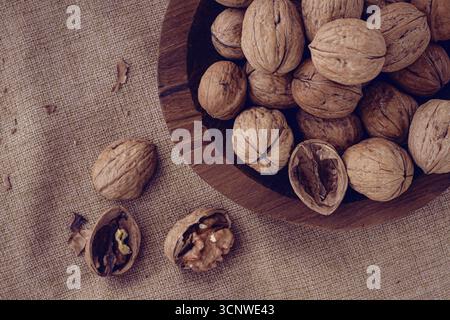 Freshly picked walnuts, in a wooden bowl, on a wooden table, rustic style, no people Stock Photo