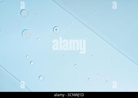 Close-up view of small water bubbles on a smooth blue surface, creating an abstract and calming visual. The pattern of the bubbles adds a soothing tex Stock Photo