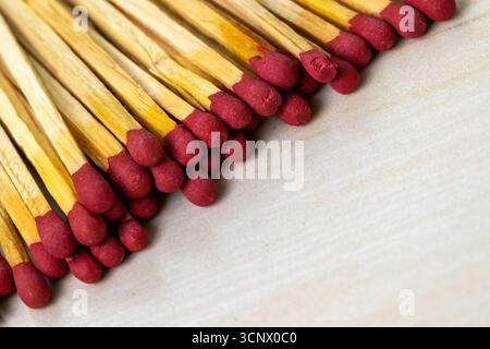 Stack of match sticks on a wooden textured background. Matchsticks are very useful for starting a fire, lighting a candle, burning paper, etc. Stock Photo