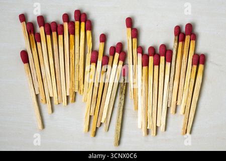Many match sticks on wooden textured background. Matchsticks are very useful to start a fire, light up a candle, burn paper, etc. It is a short, slend Stock Photo