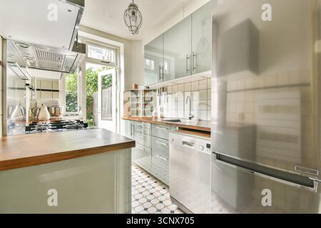 Stylish and functional kitchen featuring a blend of contemporary design and natural lighting, creating an inviting atmosphere for cooking and dining Stock Photo