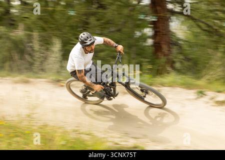 A thrilling mountain biking experience captured in Zermatt, Valais, Switzerland. A biker navigates through a rugged trail, showcasing the excitement a Stock Photo