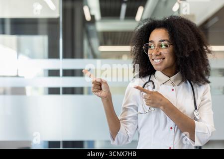 A hospital employee wears a lab coat with the words “healthcare worker ...