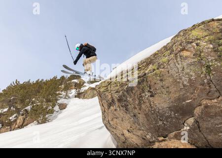 Anonymous skier performing an exciting freeride jump on snow-covered slopes in the Pyrenees, capturing the thrill of winter sports and the beauty of m Stock Photo