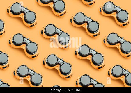 Multiple pairs of durable, yellow and black protective goggles arranged neatly on a bright background. Ideal for ensuring safety in construction and i Stock Photo