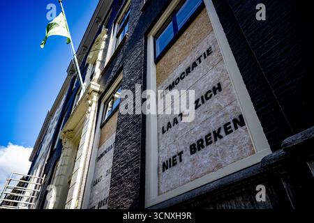 THE HAGUE - "Democracy will not be broken" is written on the D66 party office. Protesters smashed the office windows after an anti-immigration demonstration got out of hand on Malieveld. ANP /HOLLANDSE HOOGTE /ROBIN UTRECHT netherlands out - belgium out Stock Photo