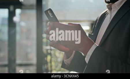 Close up male hands mature businessman texting message on smartphone smiling middle-aged 40s ethnic African American man using mobile phone apps Stock Photo