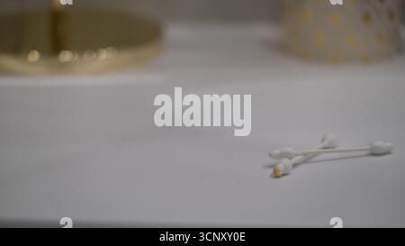 Close up of several used cotton swabs with earwax on a bathroom surface. Concept image for hygiene, ear care, healthcare, cleaning routines, and medic Stock Photo