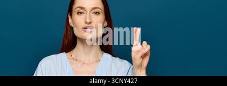 Woman with red hair teaches sign language while engaging students in a vibrant blue background. Stock Photo