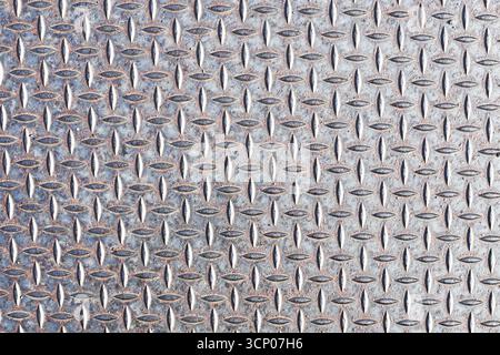 Metal steel plate with diamond pattern. Industrial textured background. Silver shiny surface with raised lines. Construction material detail. Stock Photo