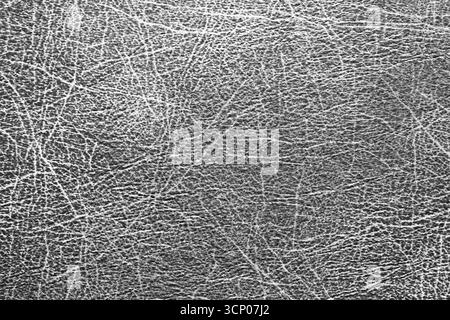 Gray leather surface with natural scratches and cracks. Closeup of texture background. Material detail for design. Abstract rough pattern. Stock Photo