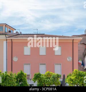Orange trees and colorful buildings in the central square of Massa, Italy Stock Photo